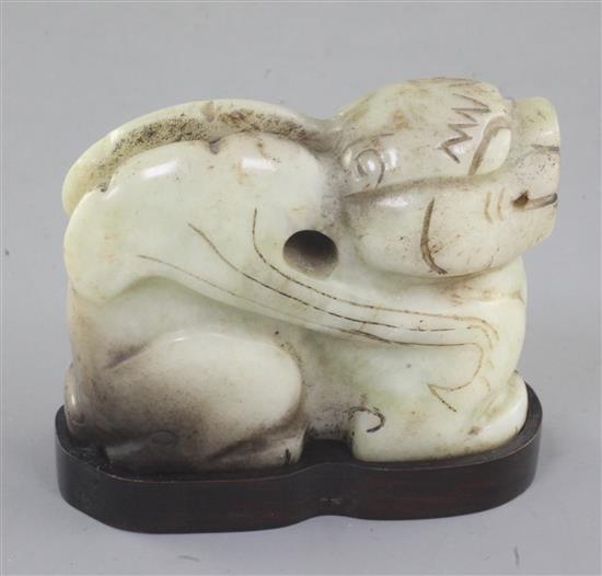 A Chinese pale celadon and black jade recumbent figure of a winged mythical beast, length 7cm, wood stand, some black staining to the s